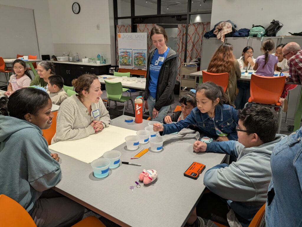 Families and library staff at a One Water STEM activity table