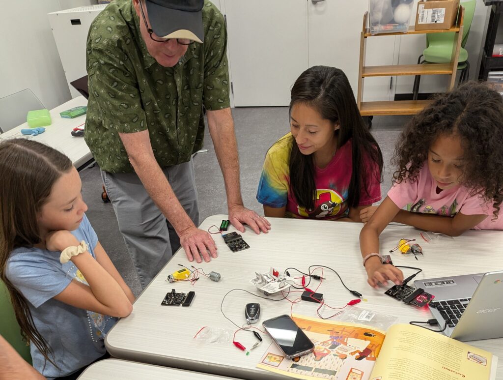 A family building circuits together at a robotics workshop